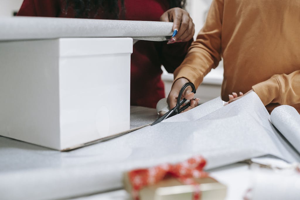 Photo of a Person's Hands Cutting Wrapping Paper
