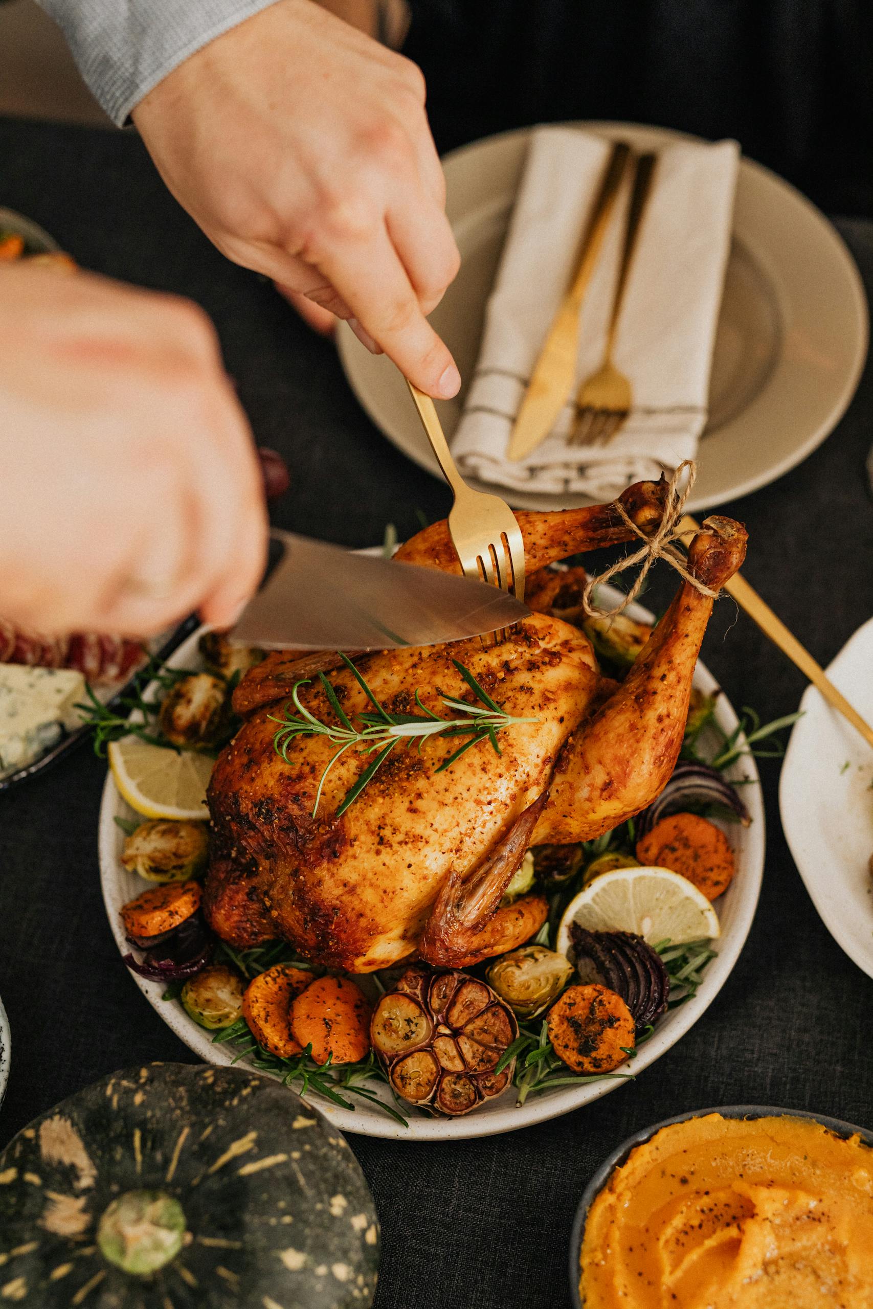 Person Cutting Turkey on Thanksgiving Table