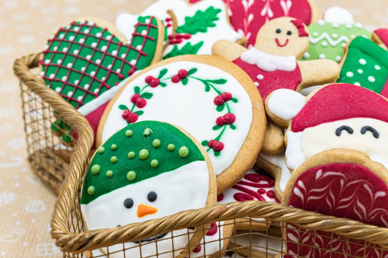 A colorful assortment of decorative Christmas cookies in a basket, perfect for holiday celebrations.